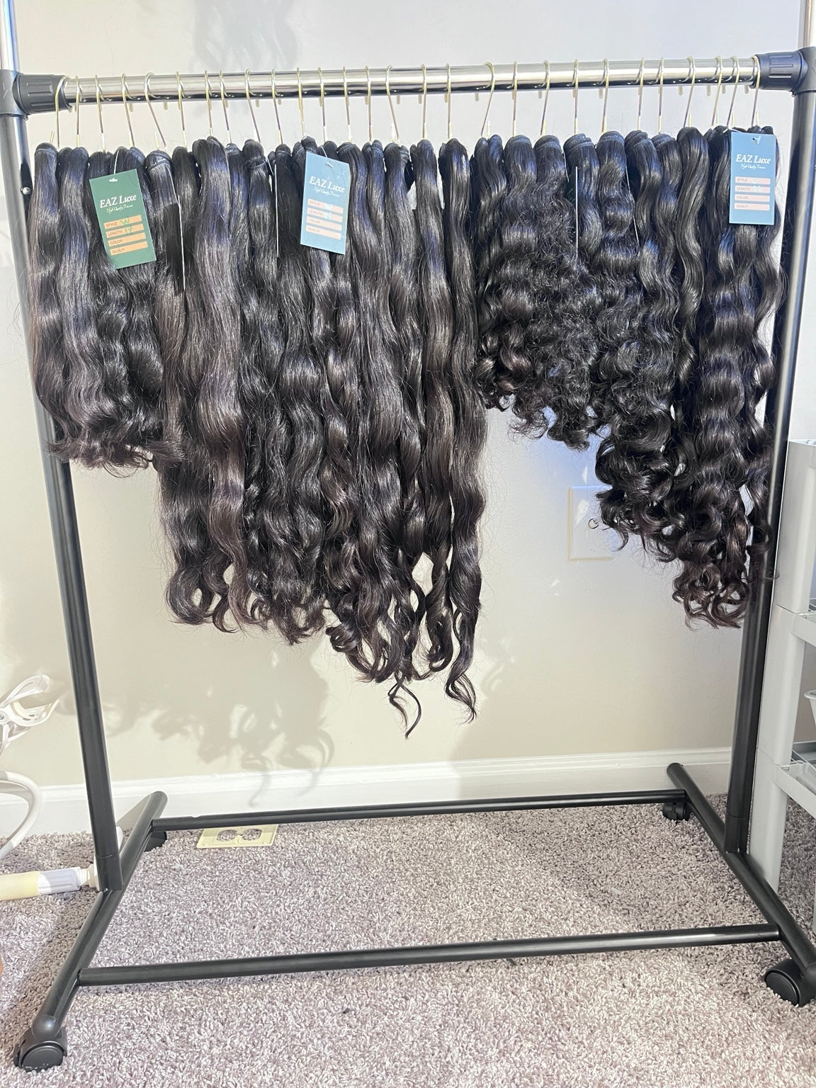 Full rack of Raw SEA hair bundles showing multiple textures and natural variation