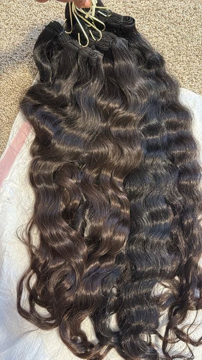 Close-up of Raw SEA Wavy bundles showing natural wave pattern, shine and color variation